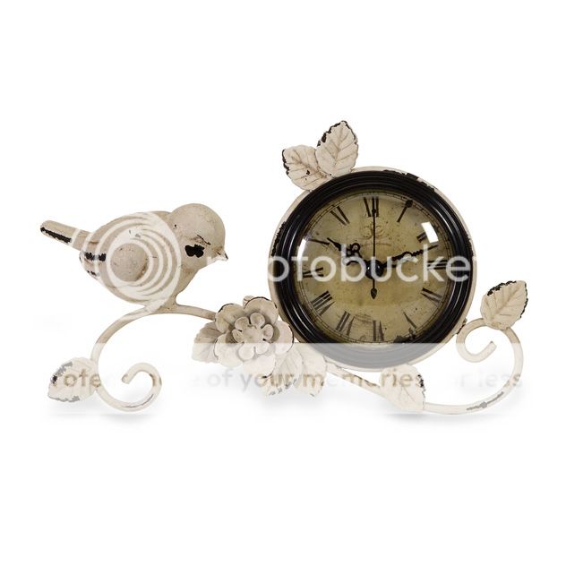   distressed finish clock has bird and leaf accents with roman numerals